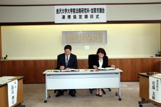 白い机の前に、男性と女性が並んで座っている画像