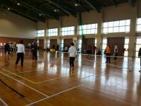 石川県スポーツ推進委員研修会の参加者達が体育館で低く設置されたネットを挟んで競技を行っている写真