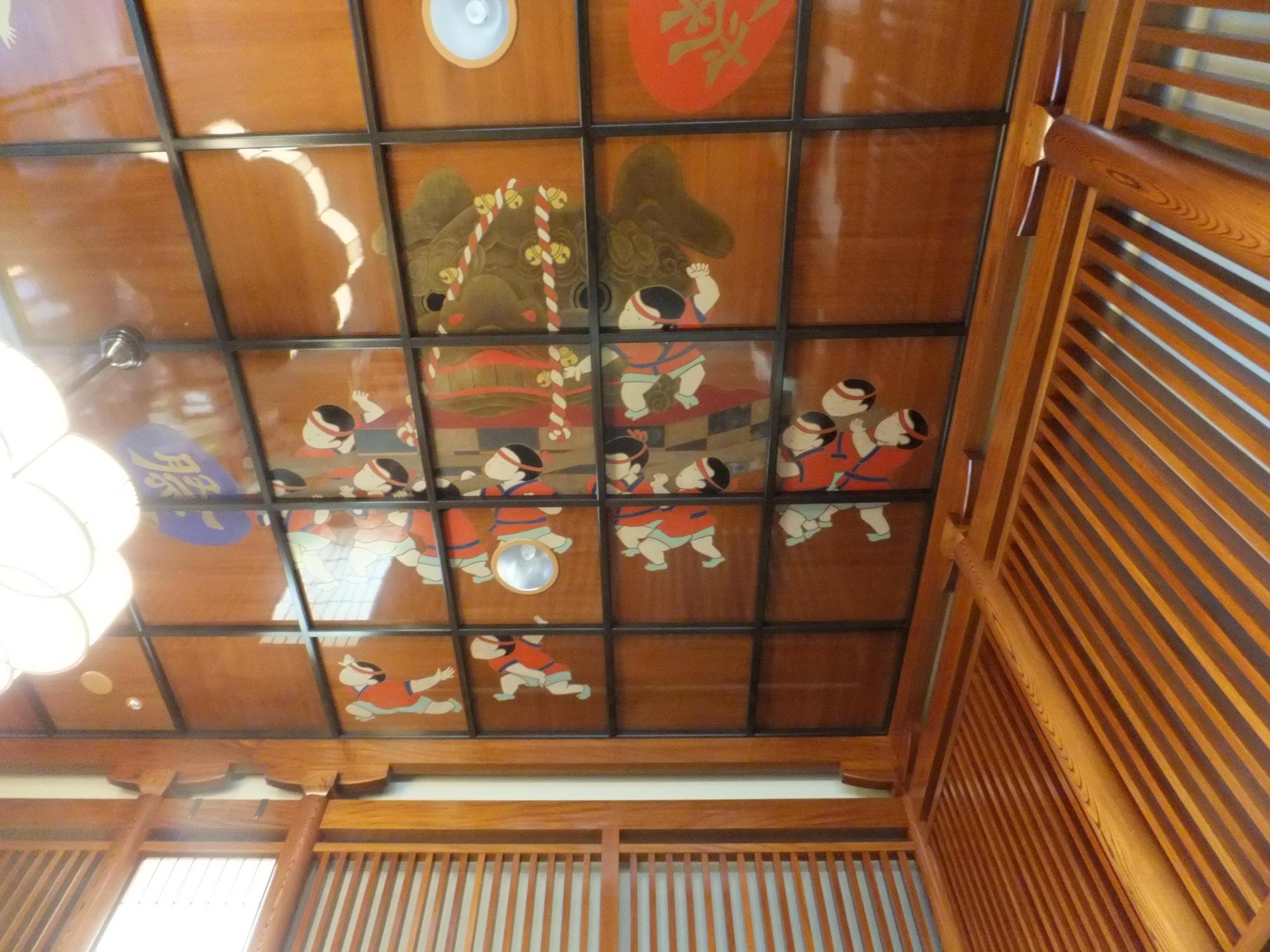おみこしを担ぐ子供たちの蒔絵が描かれた天井の写真