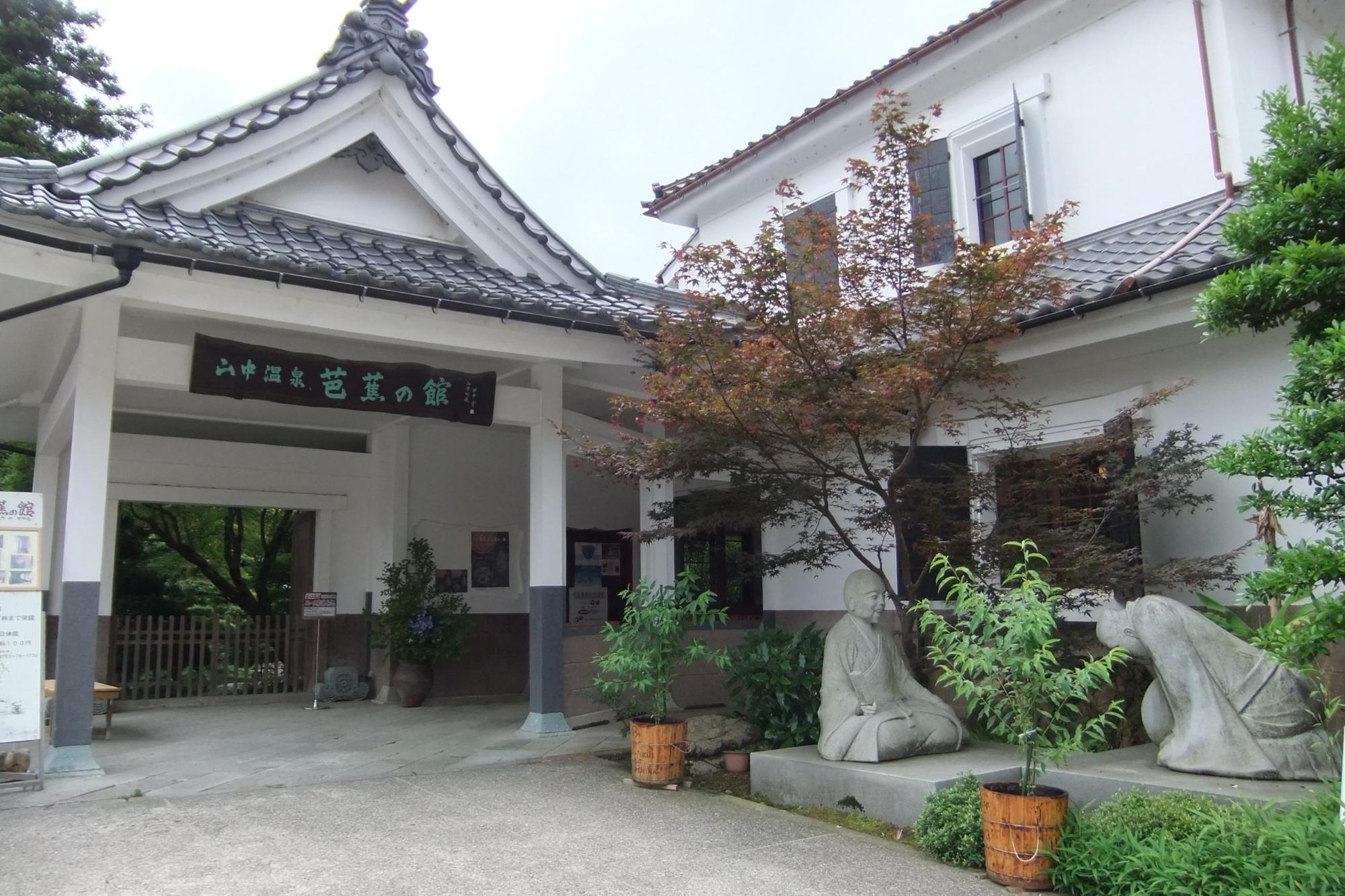 芭蕉の館の入口門と門右側に植えられてある植栽の写真