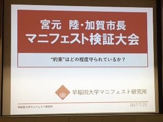 宮本 陸・加賀市長マニフェスト検証大会 ”約束”はどの程度守られているか？早稲田大学マニフェスト研究所と映し出されたプロジェクタースクリーンの写真