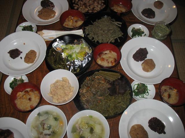 山菜やキノコなどを使用した郷土料理がテーブルいっぱいに並んでいる写真